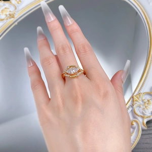 Detailed close-up of 18K gold ring with marquise-cut stone and pavé band worn on hand