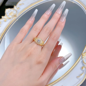 Détail de la bague florale dorée avec cristal central et finition brossée à motifs cœurs