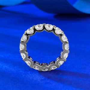 Eternity ring in S925 sterling silver with round cut moissanite on blue velvet background