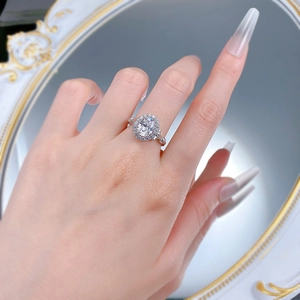 Nahaufnahme eines S925 Silberrings mit ovalem Edelstein und Halo-Fassung an der Hand