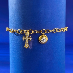 Dettaglio del bracciale in argento S925 dorato con croce pavé e ciondoli diamanti
