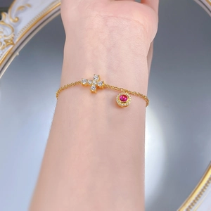 Gros plan d'un bracelet en argent S925 doré avec croix et pierre de cornaline rouge