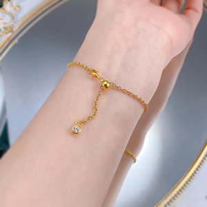 Gros plan détaillé d'une perle coulissante dorée et d'un charm en zircon sur un bracelet en argent