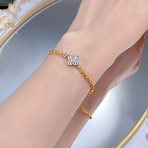 Detail of S925 silver four-pointed star bracelet with inset diamonds on gold chain