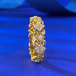 Bague vintage dorée ajourée avec zircons blancs sur fond bleu, style luxueux