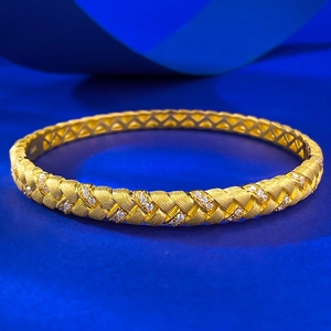 S925 silver gold-plated braided bangle with white zircon inlays on blue background