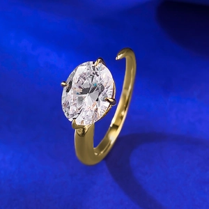 Detail of a 7x9 oval white gemstone ring with a gold four-prong setting on blue velvet