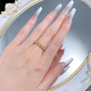 Détail de la bague fleur d'iris dorée ornée de zircons portée à la main