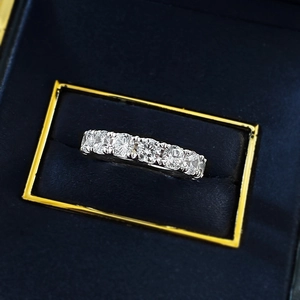 Macro detail of S925 silver eternity ring with 4mm round pavé moissanite in a blue velvet box