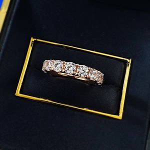 Macro detail of rose gold eternity ring with round-cut stones in a premium velvet box