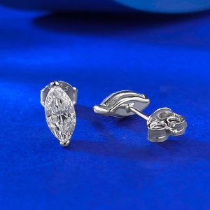 Macro shot of 4x8mm marquise-cut S925 sterling silver stud earrings on blue surface