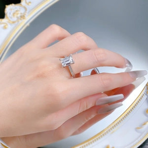 Macro view of a 7x10mm rectangular crystal silver ring with pavé detailing on a hand