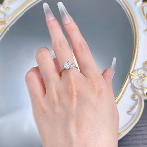 Detail of 7x9mm oval-cut clear gemstone ring in silver claw setting on model's hand