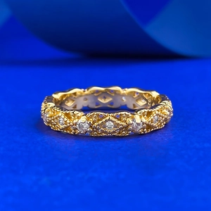 Vintage hollow gold S925 silver ring with lace design and crystals on a blue background
