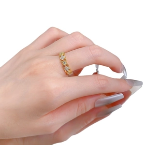 Bague fleurs évidées dorées avec cristaux brillants sur la main sur fond blanc épuré