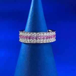 Vue détaillée de la bague pavée à trois rangées avec pierres roses et blanches