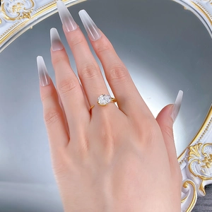 Detail of 925 silver gold-plated ring with oval cut zircon on a woman hand