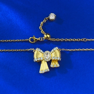 Elegant gold-plated S925 silver bow necklace with sparkling diamonds on blue silk background