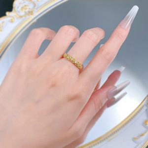 Detail of vintage hollow lace ring with gold finish and inlaid white diamonds