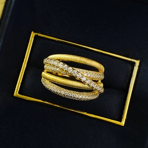 Italian brushed gold crisscross ring with pavé diamonds in a navy jewelry box