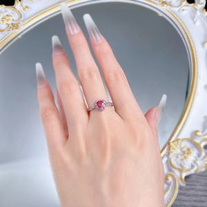 Close-up of S925 silver ring with red heart-shaped gemstone and crystal halo on finger
