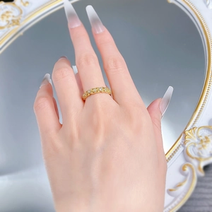 Detailed shot of vintage gold twisted lace ring with micro-set white crystals on finger