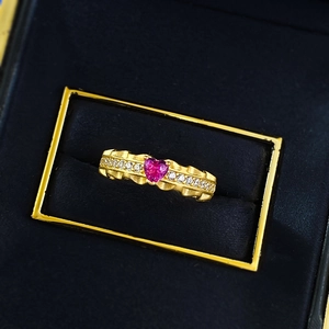 Detailed macro of gold S925 ring with heart-shaped pink diamond and wavy texture