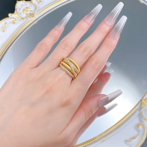Detail of gold-plated S925 silver crisscross ring with pavé diamonds on a model hand
