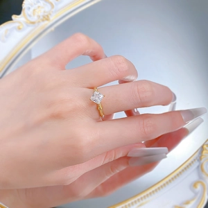 Détail d'une bague dorée avec cristal princesse et anneau texturé en style bambou