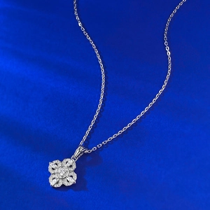 Vue macro d'un pendentif floral en argent serti de zircons sur fond de velours bleu