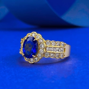 French style halo ring featuring oval blue sapphire and pavé diamonds in gold plating