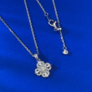 Gros plan du collier avec pendentif trèfle en argent S925 et zircons sur fond bleu