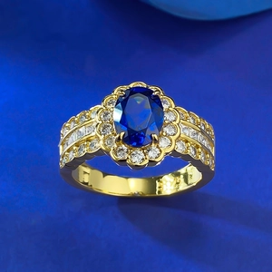 Detail of S925 silver gold-plated ring featuring oval blue sapphire and halo setting