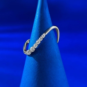 Detail of S925 silver wavy ring featuring sparkling pavé stones on a blue conical stand