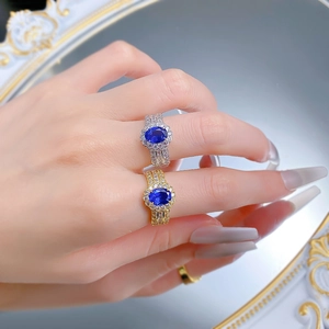 Close-up of luxury oval blue sapphire rings with halo diamonds on a vintage mirror