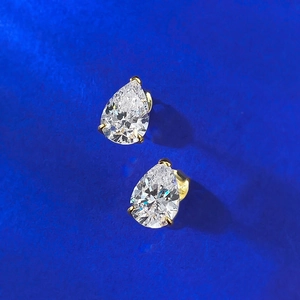 Vue macro détaillée de boucles d'oreilles moissanite poire avec griffes dorées