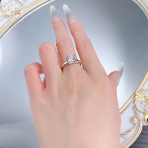 Close-up of a classic four-prong solitaire silver ring worn on a finger