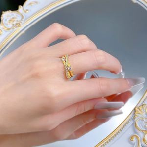 Détail d'une bague triple anneau dorée avec texture brossée et cristaux pavés