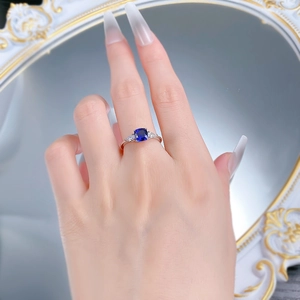 Detailed close-up of a silver ring with a square-cut blue sapphire and side diamonds