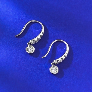 Dettaglio macro di orecchini pendenti in argento S925 con pietre di zircone tondo lucido
