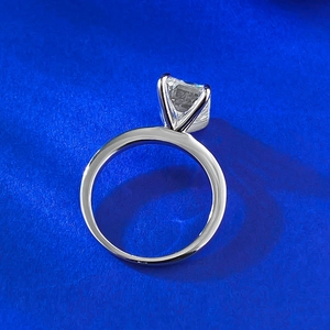 S925 Silberring mit Smaragdschliff Moissanit und Vier-Klauen-Fassung auf blauem Hintergrund