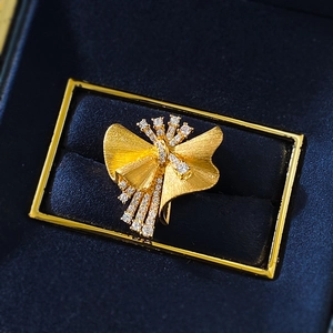 Golden brushed S925 silver brooch with sparkling diamonds on a navy velvet jewelry box