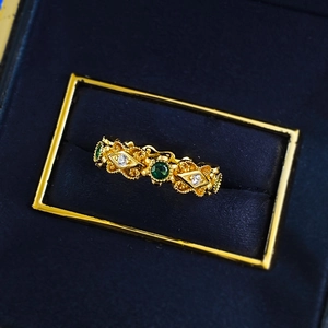 Bague vintage dorée avec gemmes vert émeraude sur boîte en velours bleu luxe
