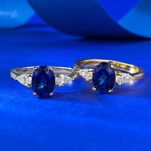 Detail of S925 silver rings featuring oval blue sapphire and pear-shaped side stones