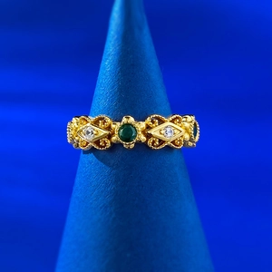 Vue macro de la bague en argent S925 avec émeraude et détails en filigrane doré baroque
