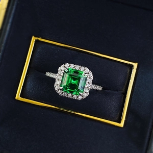 S925 sterling silver ring with square emerald cut green stone on navy velvet background