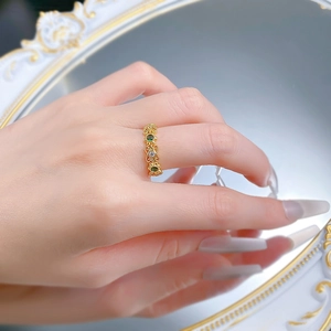 Détail d'une bague vintage en argent S925 avec dentelle et pierre verte sur main