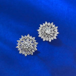 Sparkling S925 sterling silver snowflake stud earrings with pavé crystals on blue background