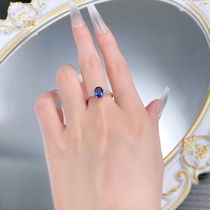 Detail view of oval sapphire ring with teardrop diamonds on a vintage mirror background