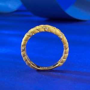 Macro shot of S925 sterling silver wheat ring with gold plating and cubic zirconia